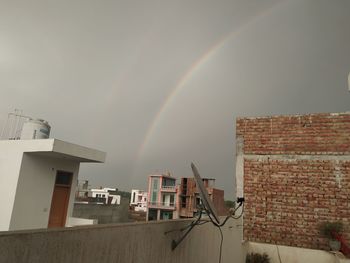 Rainbow over building against sky