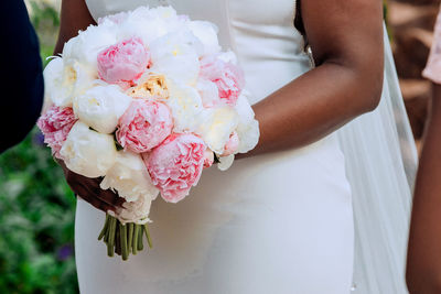 Midsection of woman holding flower bouquet