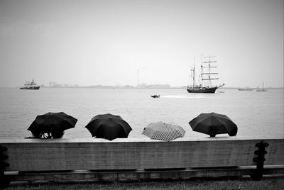 Umbrellas at sea shore against clear sky