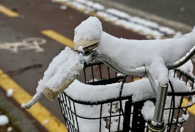 Close-up of snow covered bicycle during winter