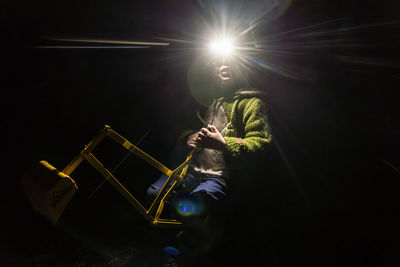 Rear view of woman sitting on stage