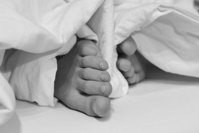 Low section of woman lying on bed