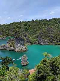 Scenic view of sea by rock formation against sky