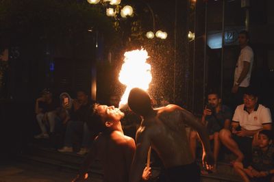 People in illuminated city at night