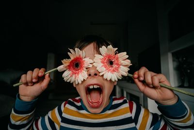 Portrait of cute boy holding flowers i  the front your eyes