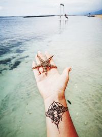 Cropped hand of person holding starfish