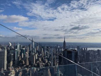 Modern buildings in city against cloudy sky