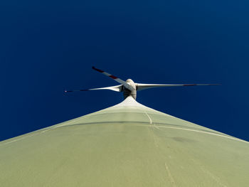 Low angle view of windmill against clear blue sky