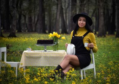 Portrait of young woman sitting on field