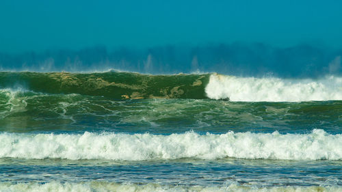 Scenic view of sea and waves against sky