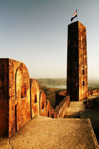 Indian flag on column at jaigarh fort against clear sky