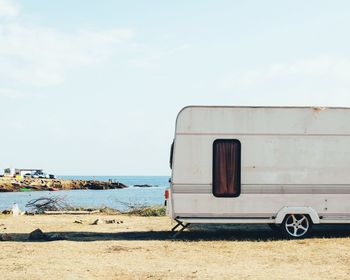 Van on beach against sky