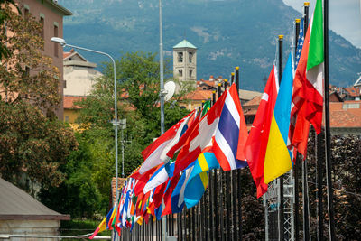 Multi colored flags on street amidst buildings in city