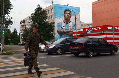 Man and cars on road in city