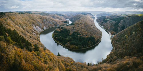 High angle view of river amidst mountains against sky