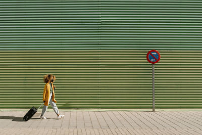 Full length of woman standing on footpath