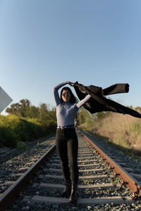 Full length of man standing on railroad track against sky