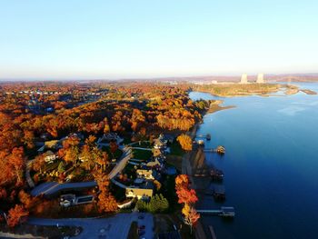 Aerial view of city by sea against sky