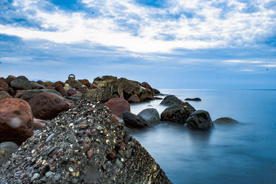 Rocks in sea against sky