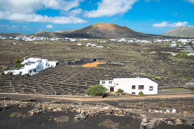 Buildings by mountain against sky