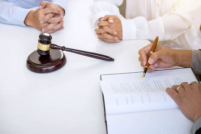 High angle view of couple sitting at desk with lawyer in court room