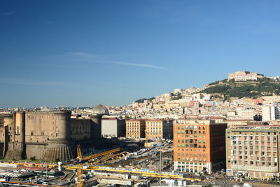 High angle view of buildings against blue sky