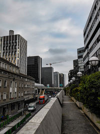 Road amidst buildings in city against sky