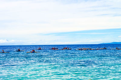 People enjoying in sea against sky