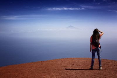 Rear view of woman looking at sea against sky