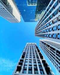 Low angle view of modern buildings against clear blue sky