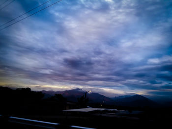 Scenic view of silhouette mountains against sky at sunset