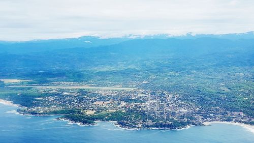 Aerial view of sea and cityscape against sky