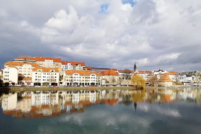 Reflection of city in water against sky