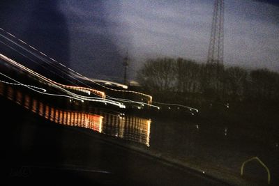 Illuminated bridge against sky at night