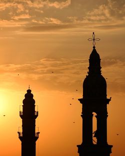 Low angle view of silhouette building against sky during sunset