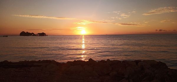 Scenic view of sea against romantic sky at sunset