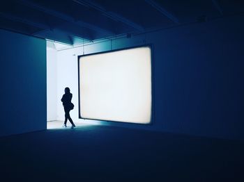 Woman walking by projection screen in board room