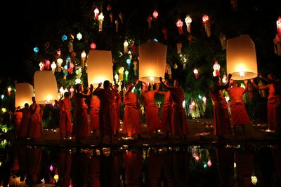 Rear view of people enjoying at night