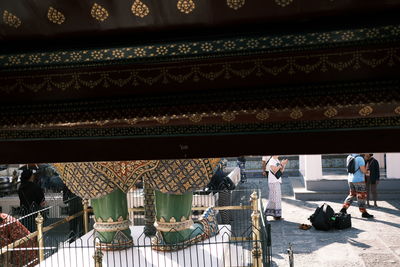 People working on temple outside building