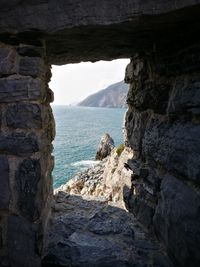 Scenic view of sea by cliff against sky