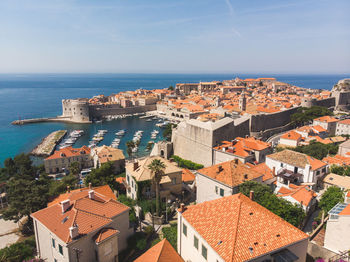 High angle view of townscape by sea against sky