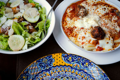 Lasagna and vegetable salad on the table.