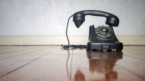 Close-up of telephone booth on table against wall