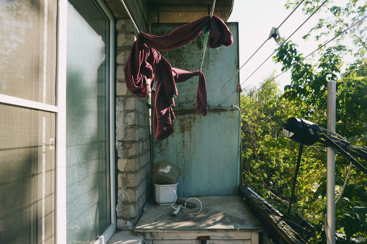 architecture, building exterior, built structure, hanging, day, plant, laundry, no people, drying, clothing, building, outdoors, nature, clothesline, house, window, front or back yard, shoe, growth, textile