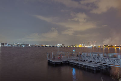 Pier over sea against sky in city