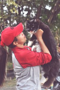 Midsection of girl with cat standing outdoors