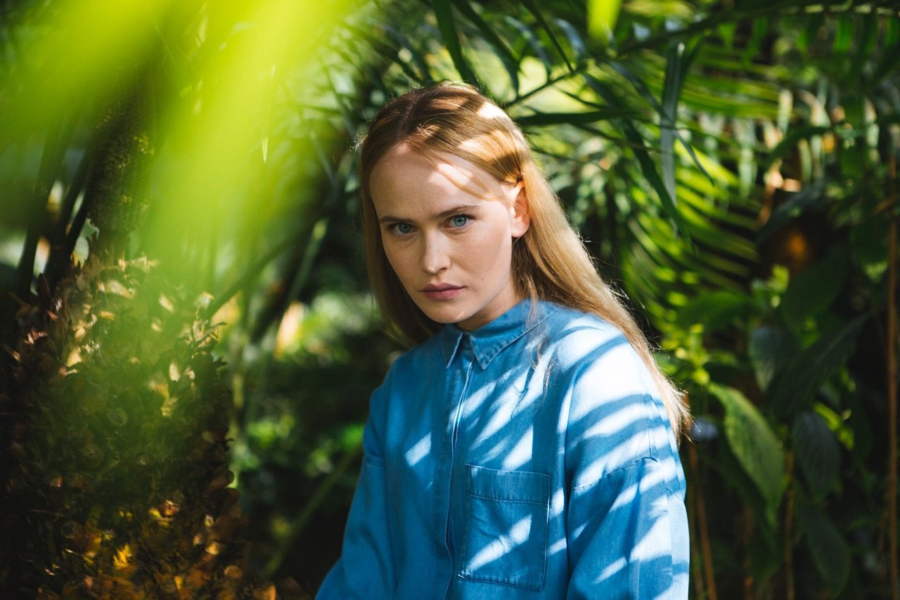 person, waist up, casual clothing, portrait, lifestyles, looking at camera, front view, leisure activity, smiling, focus on foreground, young adult, three quarter length, green color, standing, happiness, headshot, elementary age, tree