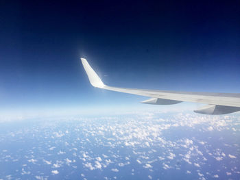 Cropped image of airplane flying over clouds