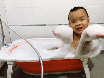 Happy boy with arms raised in bathroom