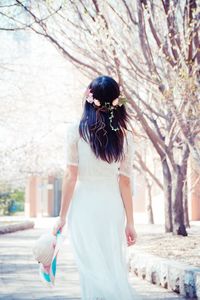 Rear view of woman with walking on road